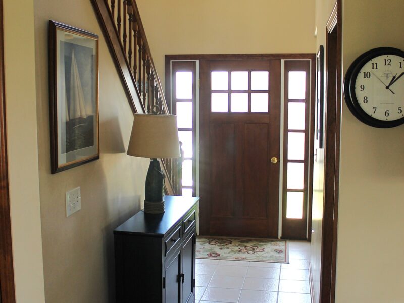 A before photo of the front hall entrance for the remodel of a 1970s colonial in Dennis, MA.